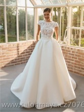 Šaty v barvě ivory, květinový krajkový top s krátkým rukávem, hladká sukně z materiálu mikádo, kapsy. 