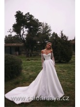 Šaty z materiálu mikádo s bohatou sukní. Falešný rozparek neodhaluje nohu, ale vsadku z třpytivé krajky. Dlouhý transparentní rukáv, který odhaluje ramena. Krajkový detail na košíčkách. Šněrování. 